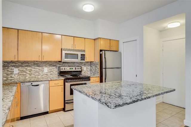 kitchen featuring backsplash, light stone countertops, light tile patterned flooring, and appliances with stainless steel finishes