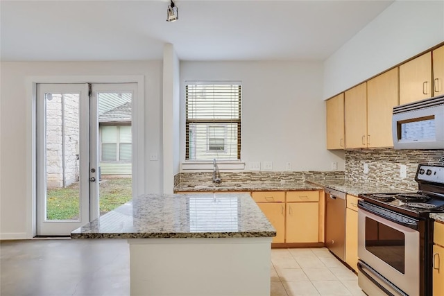 kitchen featuring sink, light brown cabinetry, appliances with stainless steel finishes, a healthy amount of sunlight, and light stone counters