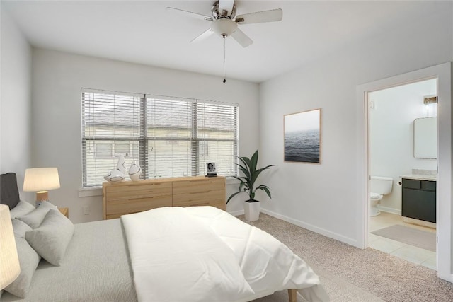 carpeted bedroom with ensuite bathroom and ceiling fan