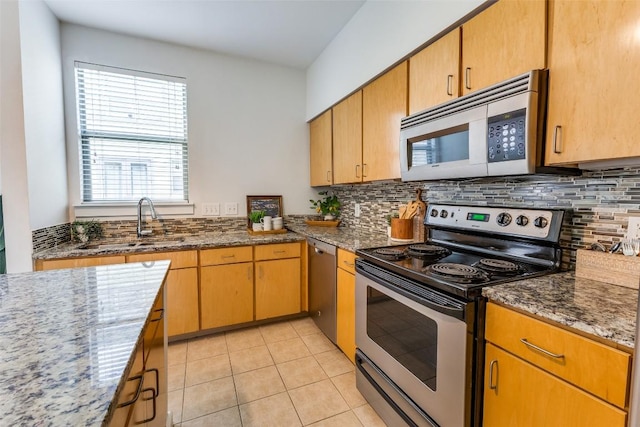 1201 Grove Blvd Unit 1102, Austin, TX 78741 - kitchen featuring appliances with stainless steel finishes, backsplash, dark stone counters, and light tile patterned floors