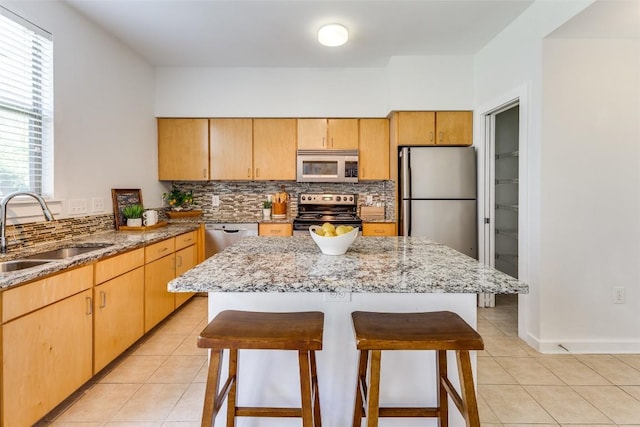1201 Grove Blvd Unit 1102, Austin, TX 78741 - kitchen with stainless steel appliances, light tile patterned floors, a breakfast bar area, and backsplash