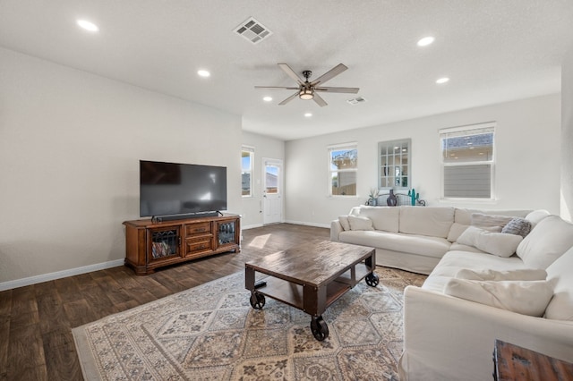 living room featuring a wealth of natural light, a textured ceiling, ceiling fan, and dark wood-type flooring