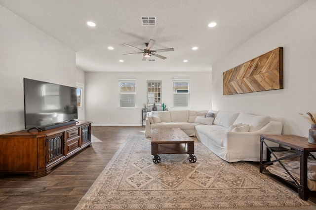 living room featuring a textured ceiling, ceiling fan, and dark hardwood / wood-style floors