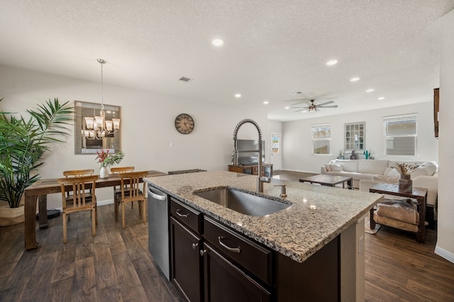 kitchen featuring pendant lighting, a center island with sink, ceiling fan with notable chandelier, sink, and stainless steel dishwasher