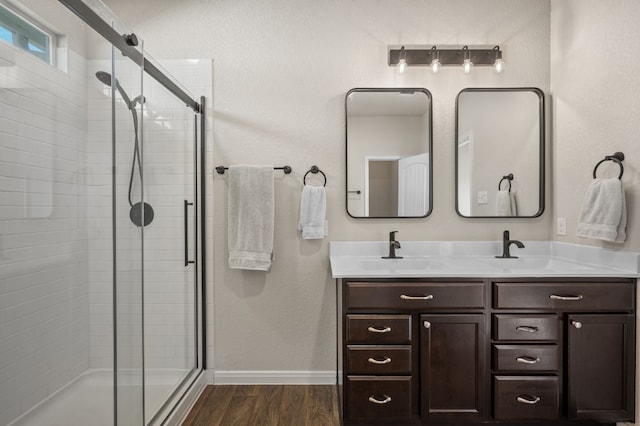 bathroom with hardwood / wood-style floors, vanity, and a shower with door