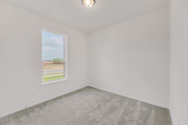 unfurnished room featuring carpet floors and baseboards