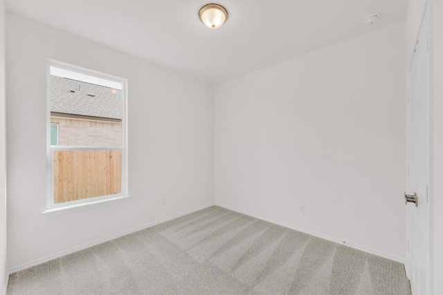unfurnished room featuring carpet floors and baseboards
