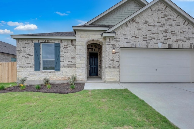 view of front facade featuring driveway, brick siding, fence, a front lawn, and an attached garage