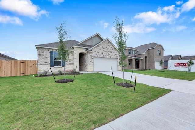 view of front of property featuring fence, an attached garage, driveway, and a front lawn