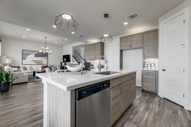 kitchen with dishwasher, dark wood-type flooring, sink, an island with sink, and a chandelier