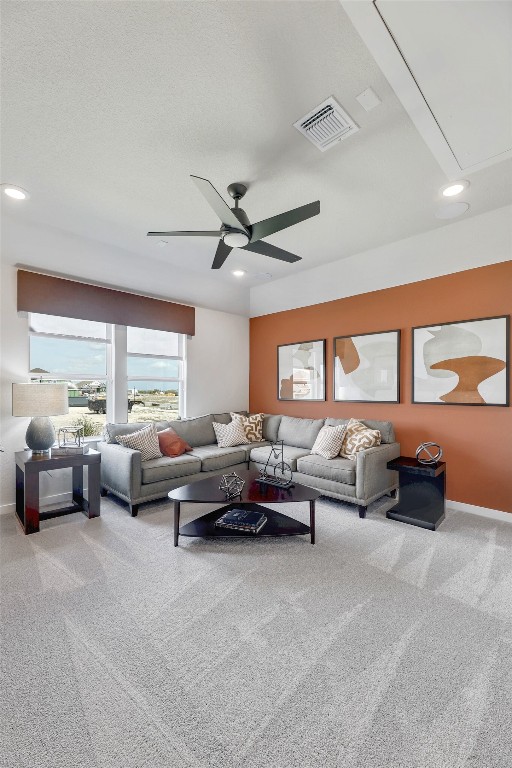 carpeted living room with ceiling fan