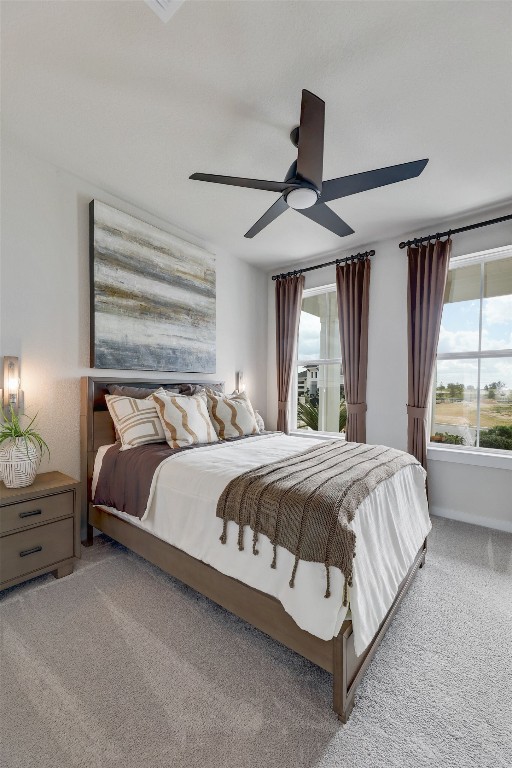 carpeted bedroom featuring ceiling fan and multiple windows