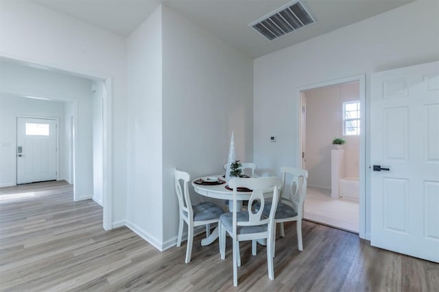 dining area with a healthy amount of sunlight and light hardwood / wood-style floors