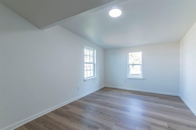 unfurnished room with light hardwood / wood-style flooring and vaulted ceiling