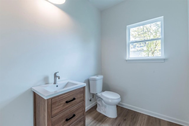 bathroom with hardwood / wood-style floors, vanity, and toilet