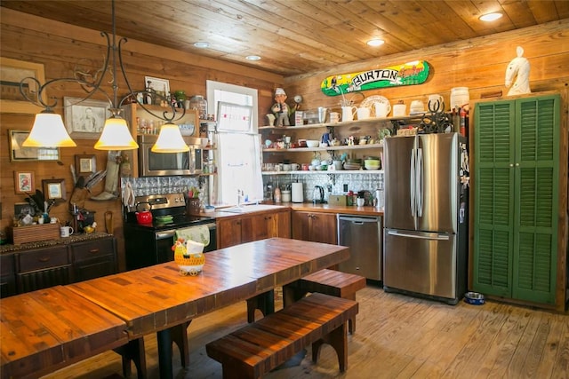 kitchen with wooden ceiling, light hardwood / wood-style flooring, decorative light fixtures, wooden walls, and appliances with stainless steel finishes