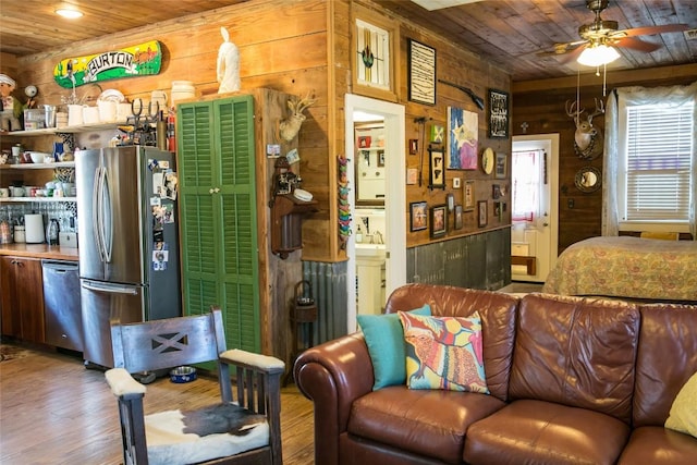 living room featuring ceiling fan, wood ceiling, and wooden walls