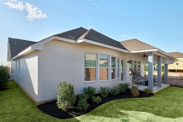 view of home's exterior with ceiling fan, a yard, and a patio