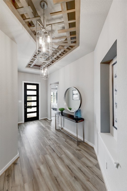 foyer with wood-type flooring and a notable chandelier