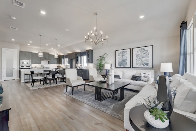 living room featuring light hardwood / wood-style floors and a notable chandelier