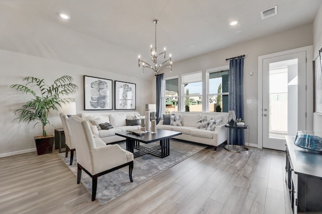 living room with light hardwood / wood-style flooring and a notable chandelier