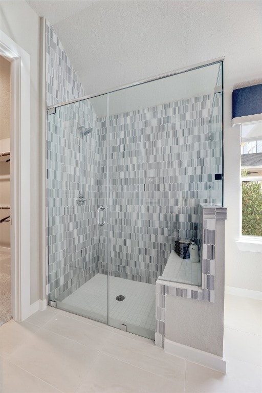 bathroom featuring tile patterned floors, a textured ceiling, and an enclosed shower