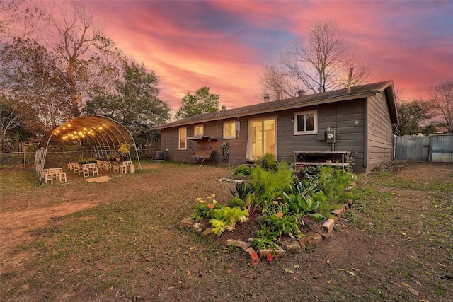 back house at dusk featuring central AC unit