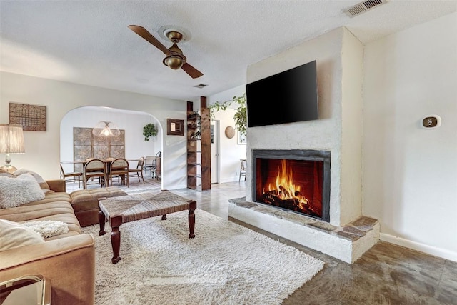 living room featuring ceiling fan and a textured ceiling