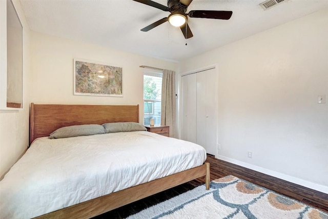 bedroom with dark hardwood / wood-style flooring, a closet, and ceiling fan