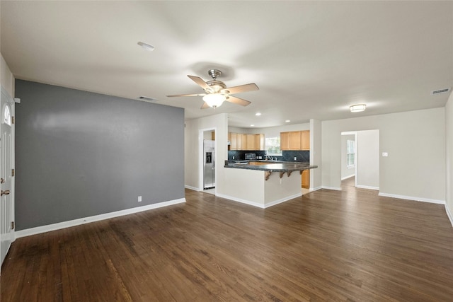 unfurnished living room featuring dark hardwood / wood-style floors, ceiling fan, and sink