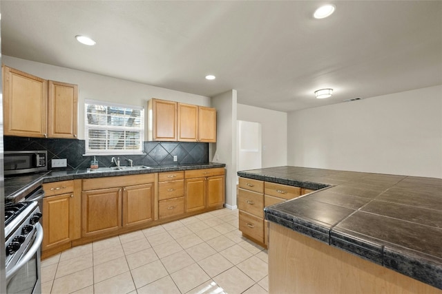 kitchen featuring light tile patterned flooring, sink, appliances with stainless steel finishes, and tasteful backsplash