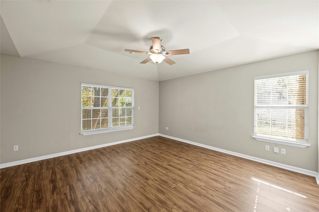 unfurnished room with a raised ceiling, ceiling fan, and hardwood / wood-style flooring