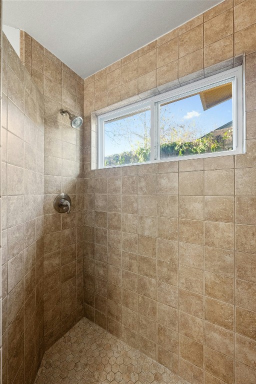 bathroom with tiled shower and a wealth of natural light