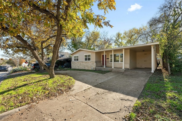 ranch-style home featuring covered porch and a carport