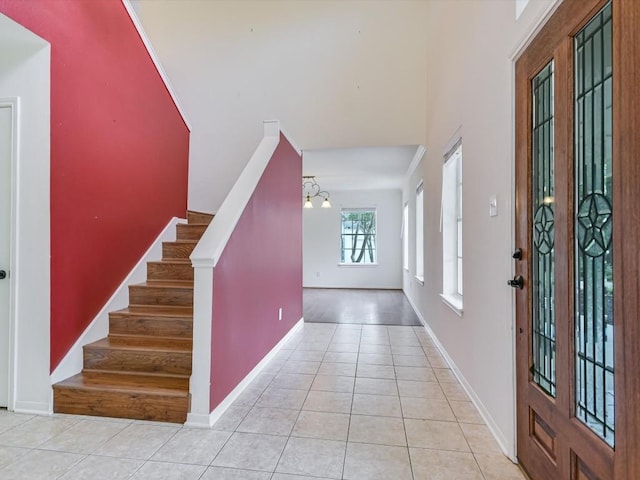 entrance foyer featuring light tile patterned floors and an inviting chandelier