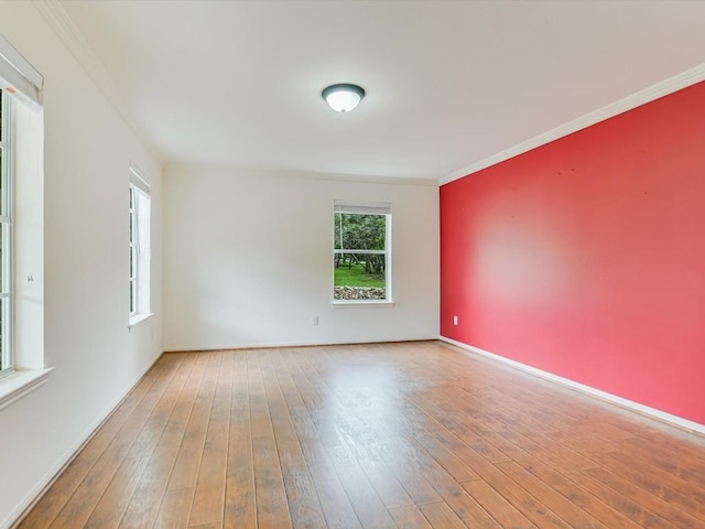 spare room featuring hardwood / wood-style flooring and ornamental molding