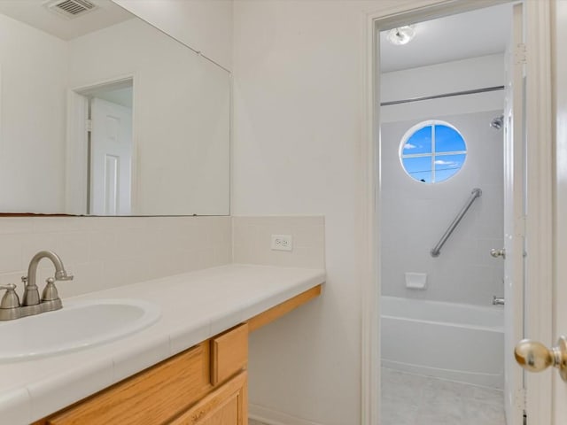 bathroom featuring vanity, bathtub / shower combination, and tasteful backsplash