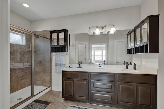 bathroom with tile patterned floors, vanity, and a shower with door