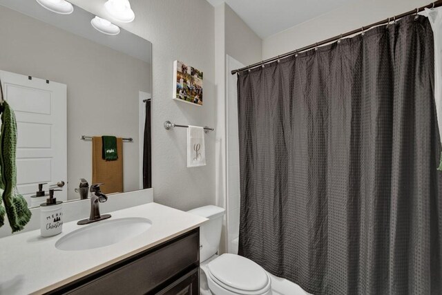 bathroom featuring vanity, curtained shower, and toilet