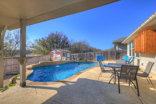 view of pool featuring pool water feature, a patio area, and a storage shed