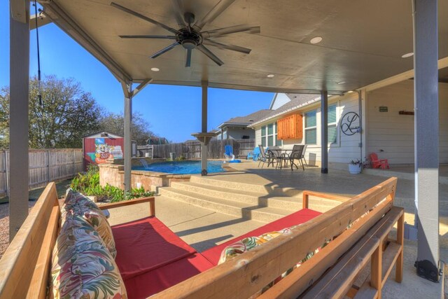 view of patio / terrace with a storage unit, a fenced in pool, and ceiling fan