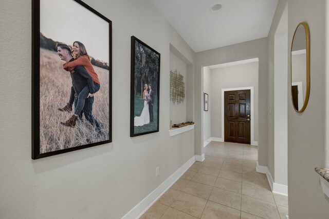 hall featuring light tile patterned floors