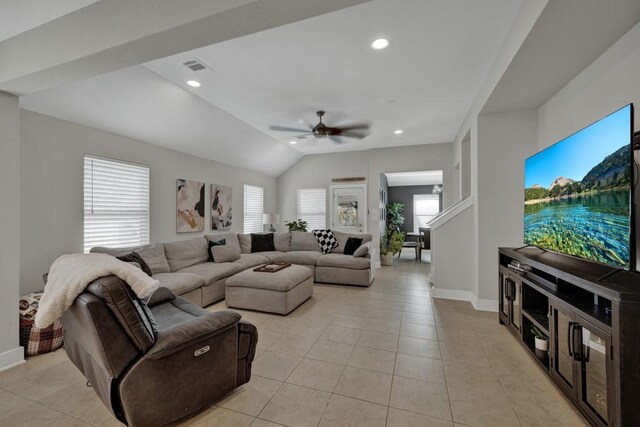 tiled living room featuring ceiling fan, plenty of natural light, and lofted ceiling