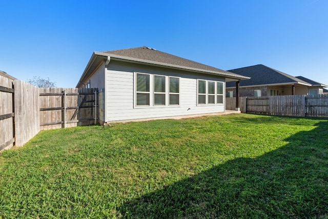 rear view of property featuring a lawn