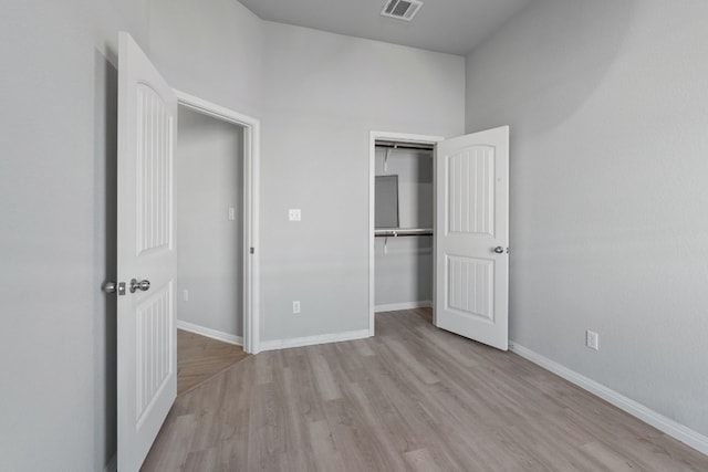 unfurnished bedroom featuring light hardwood / wood-style floors and a closet