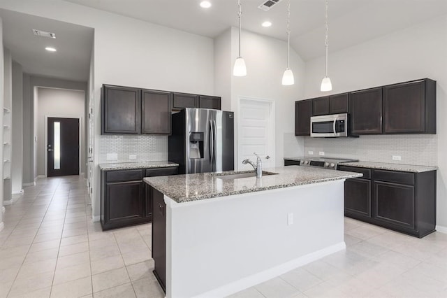 kitchen featuring pendant lighting, high vaulted ceiling, sink, an island with sink, and stainless steel appliances