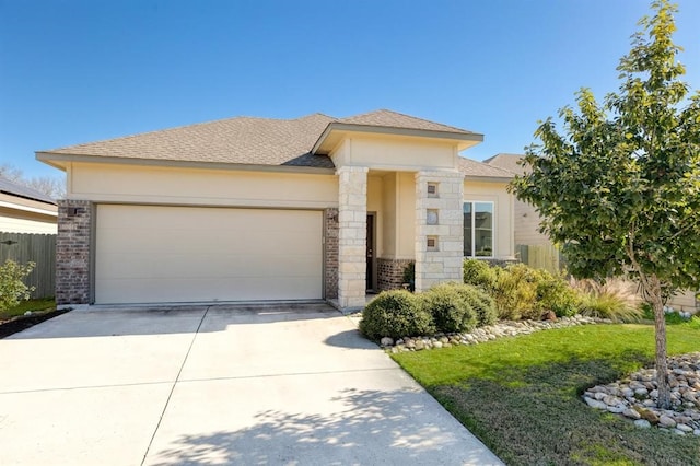 10017 Dalliance Ln, Manor, TX 78653 - prairie-style house featuring an attached garage, concrete driveway, brick siding, and roof with shingles