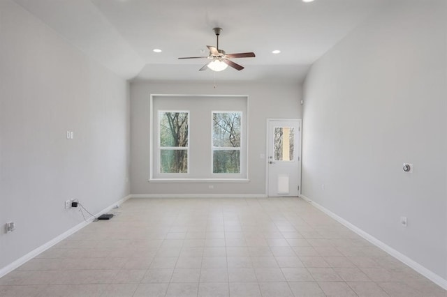 empty room featuring ceiling fan, light tile patterned flooring, and vaulted ceiling