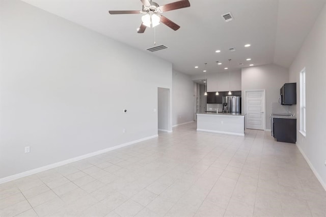 unfurnished living room with ceiling fan, light tile patterned floors, and vaulted ceiling