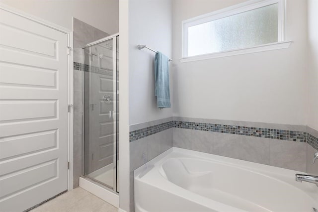 bathroom with tile patterned floors and shower with separate bathtub